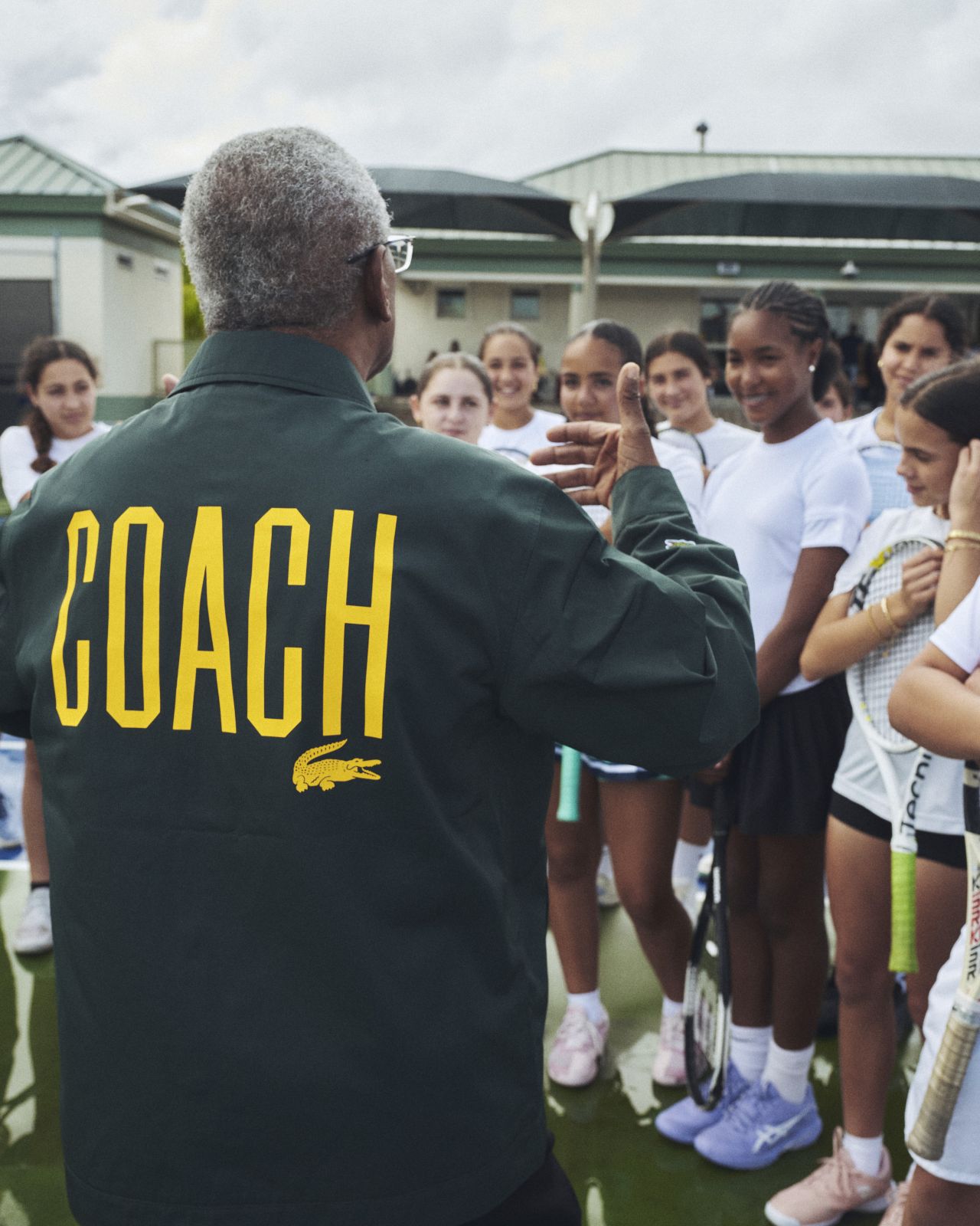 Coach addressing a group on the tennis court