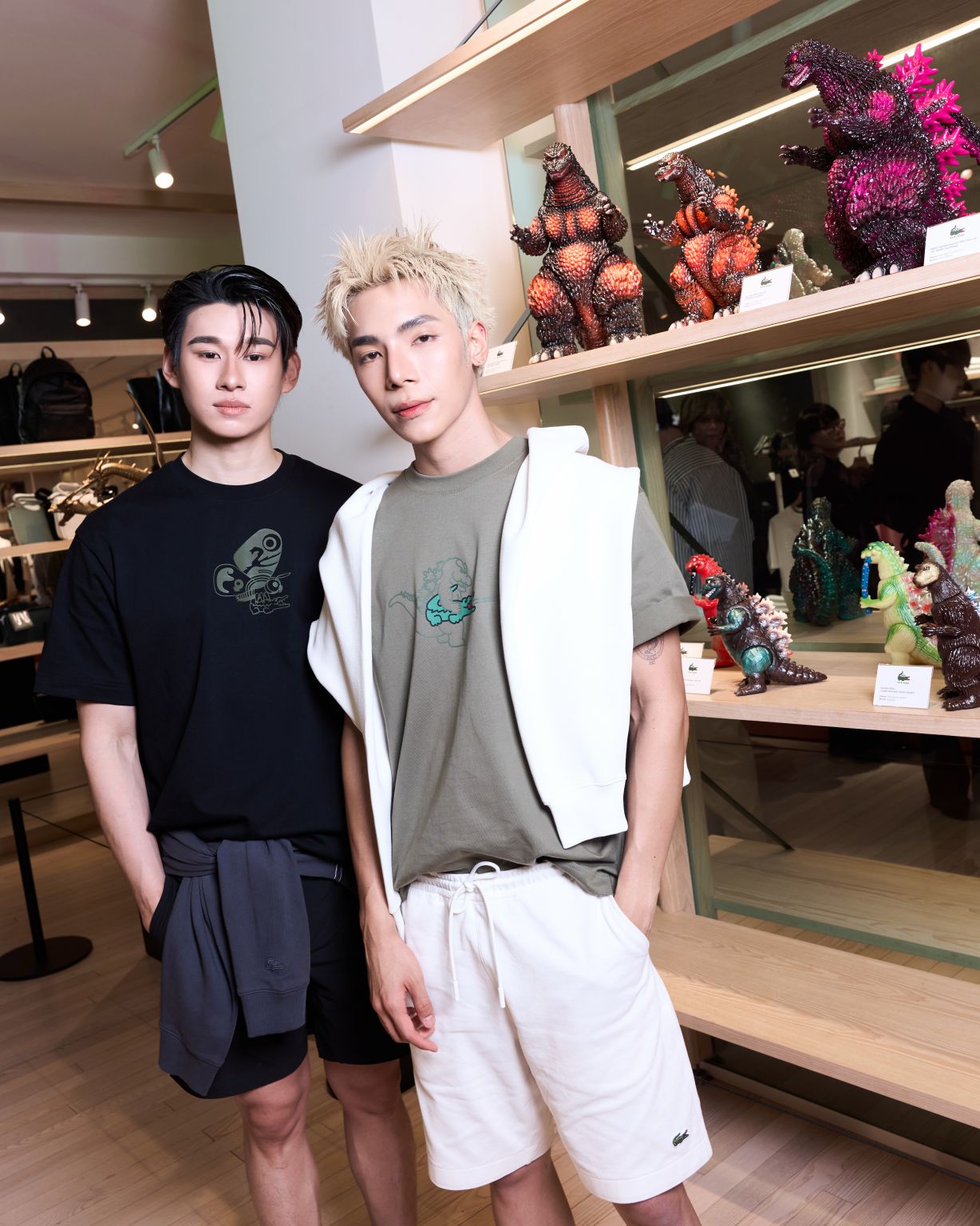 Two launch guests beside a shelf of collectible figures