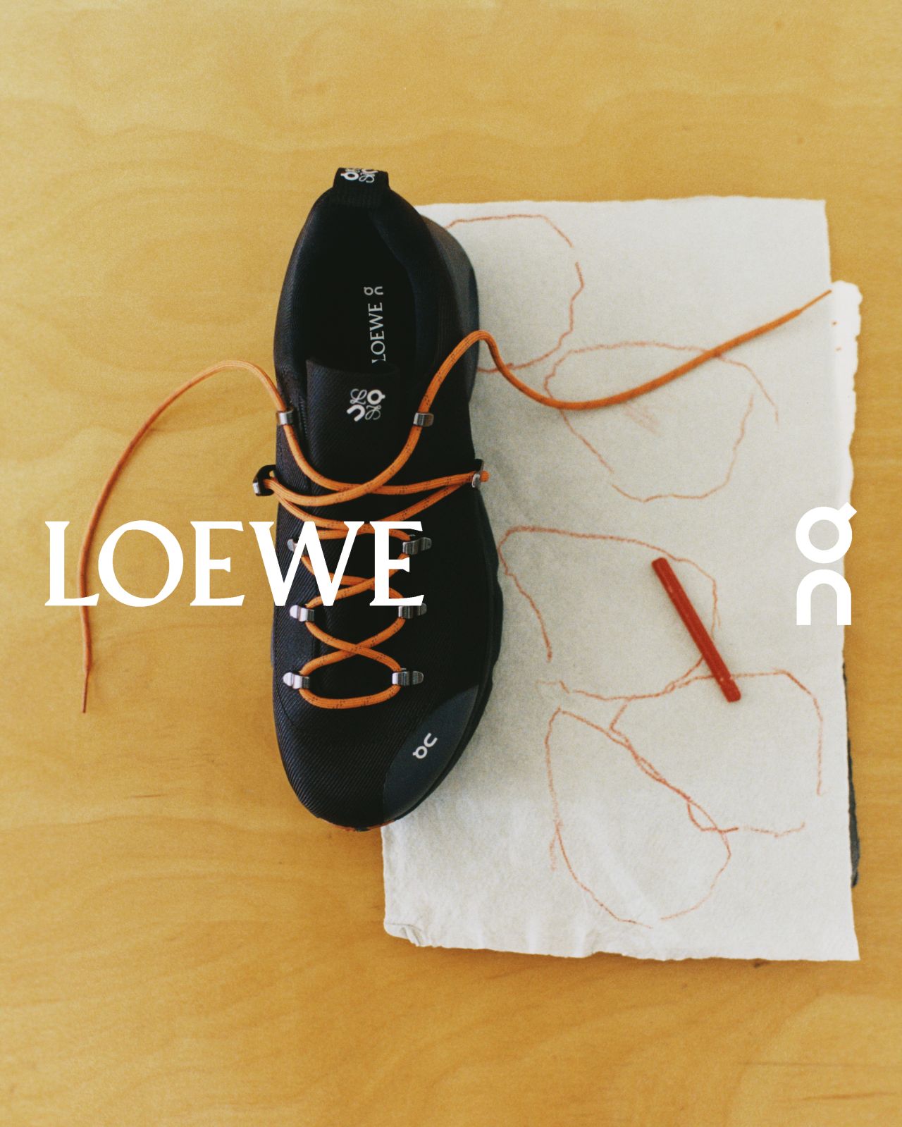 Black LOEWE and On footwear photographed with contrasting laces