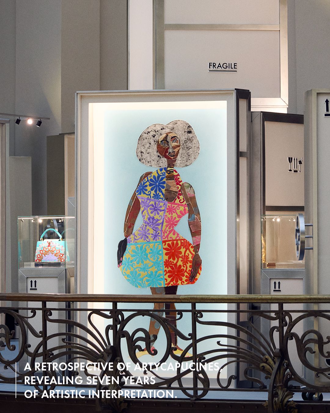 Colorful figure artwork beside Artycapucines handbags in a crate-style display, with Louis Vuitton’s retrospective text overlay.