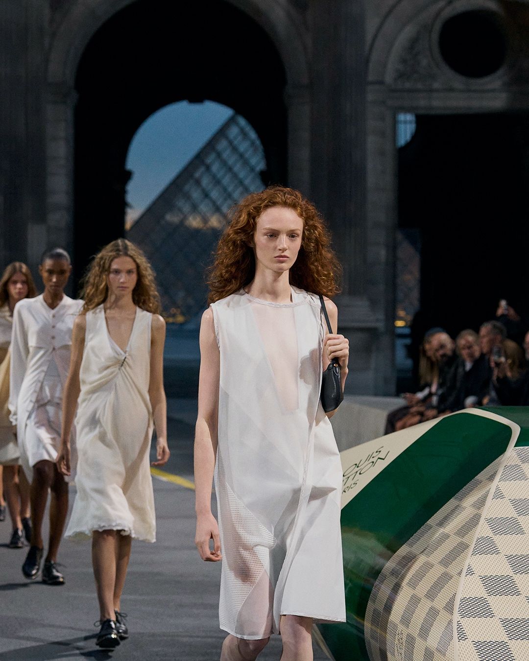 Models in light Louis Vuitton Spring/Summer 2027 looks at the Louvre