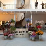 Public-facing We All Wear MAC pop-up in Paris with floral displays and campaign signage