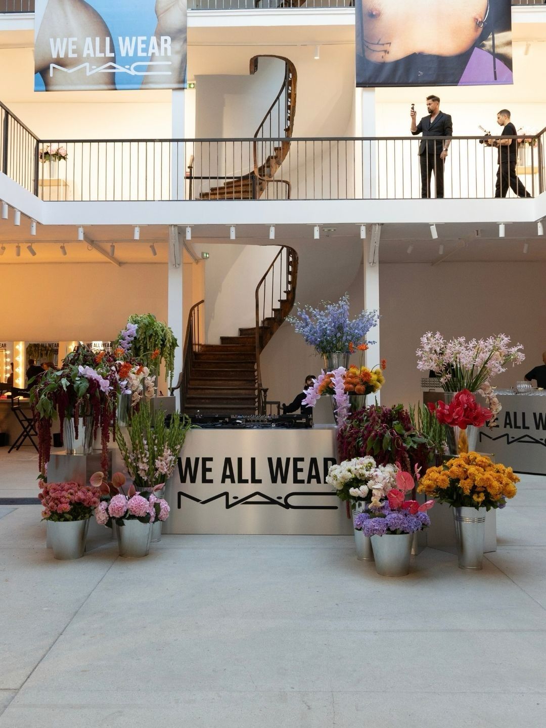 Public-facing We All Wear MAC pop-up in Paris with floral displays and campaign signage