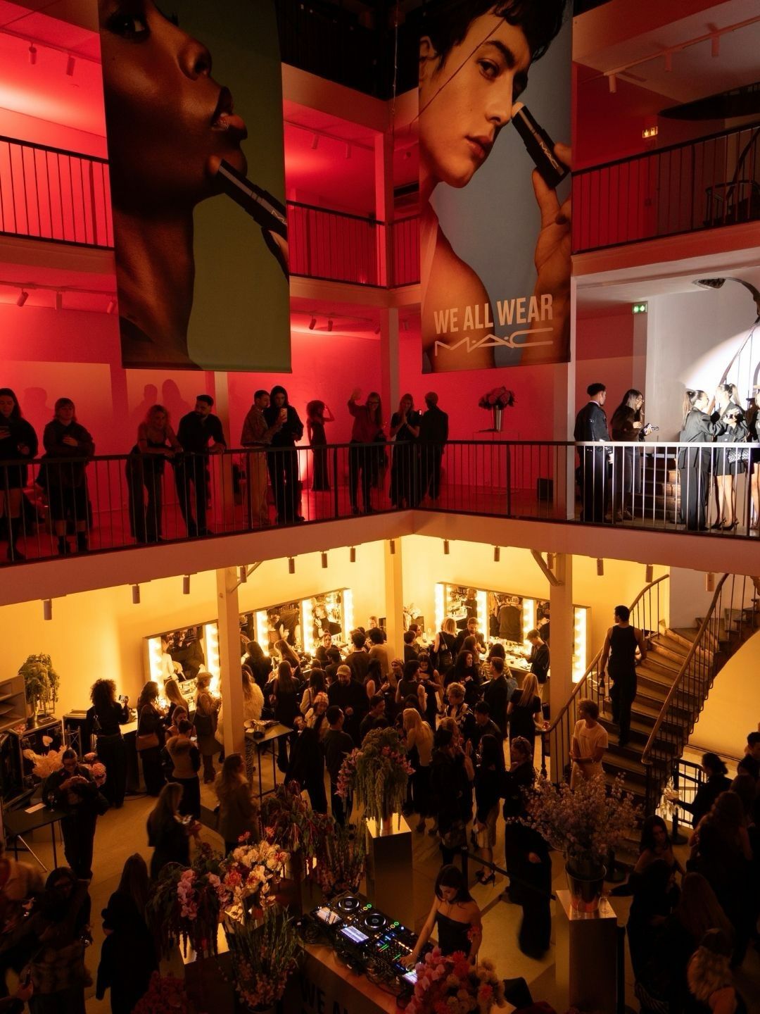 Guests inside MAC's Paris campaign launch event beneath large portrait displays