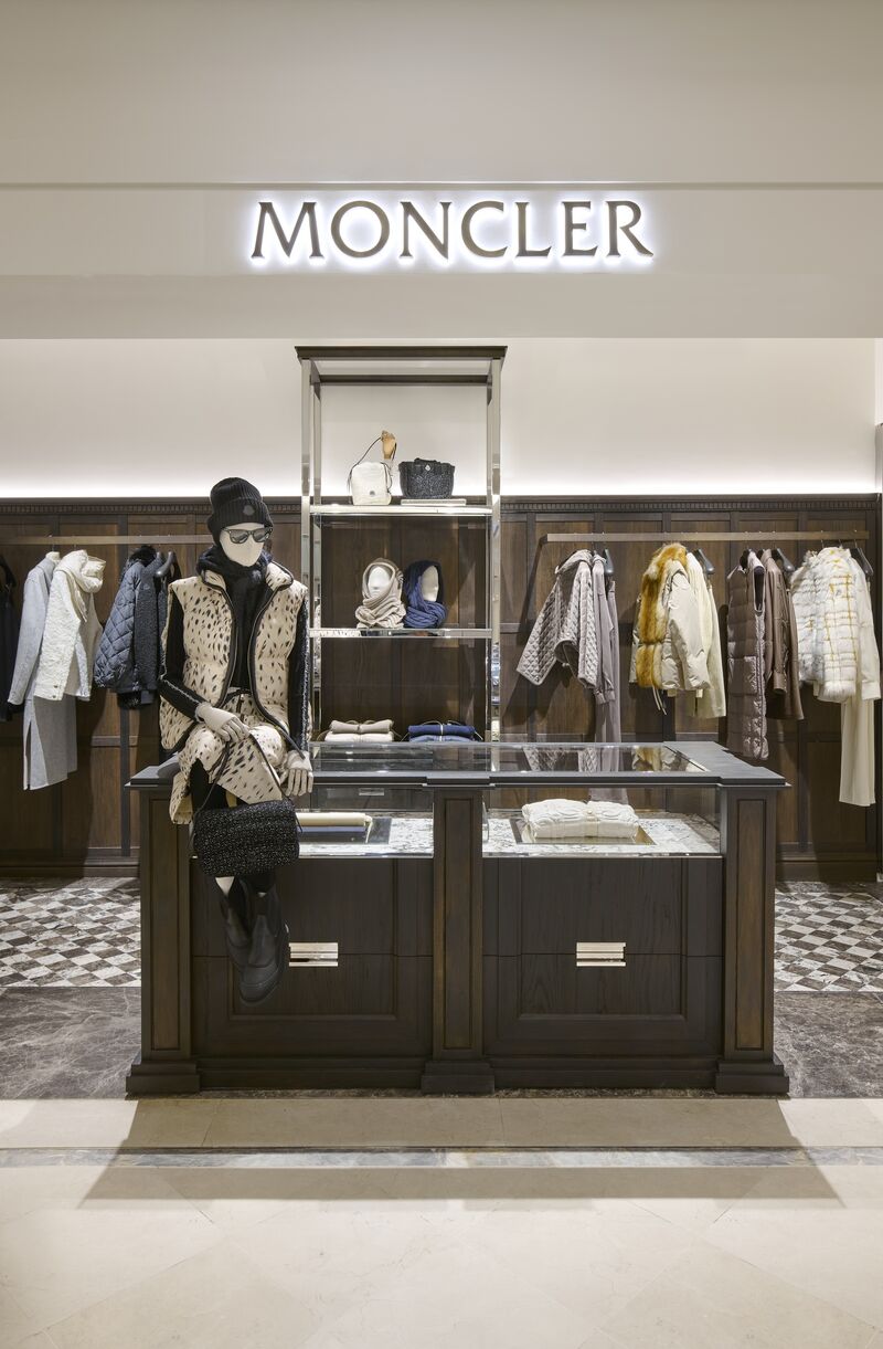 Moncler mannequins and apparel rails behind the central fixture