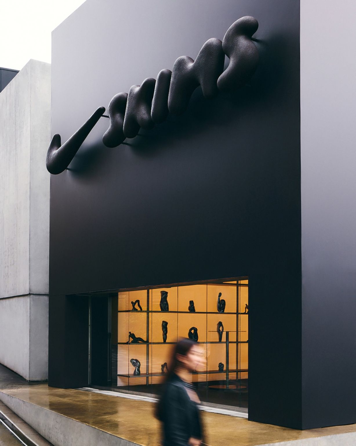 Sculptural Nike mark above a NikeSKIMS pop-up storefront