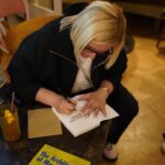 Oana Leonte signing a copy of The Architecture of Meaning at a book event