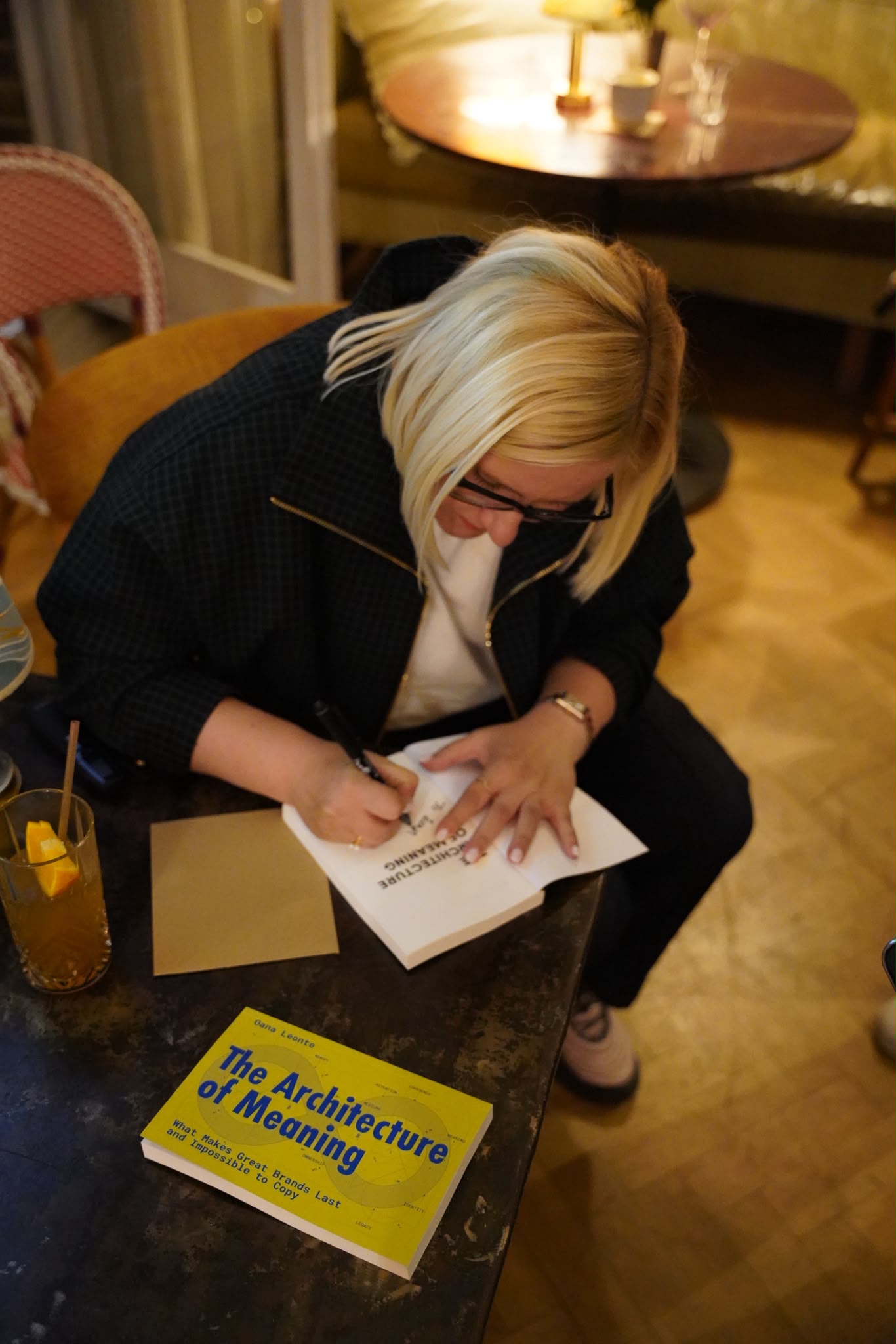 Oana Leonte signing a copy of The Architecture of Meaning at a book event