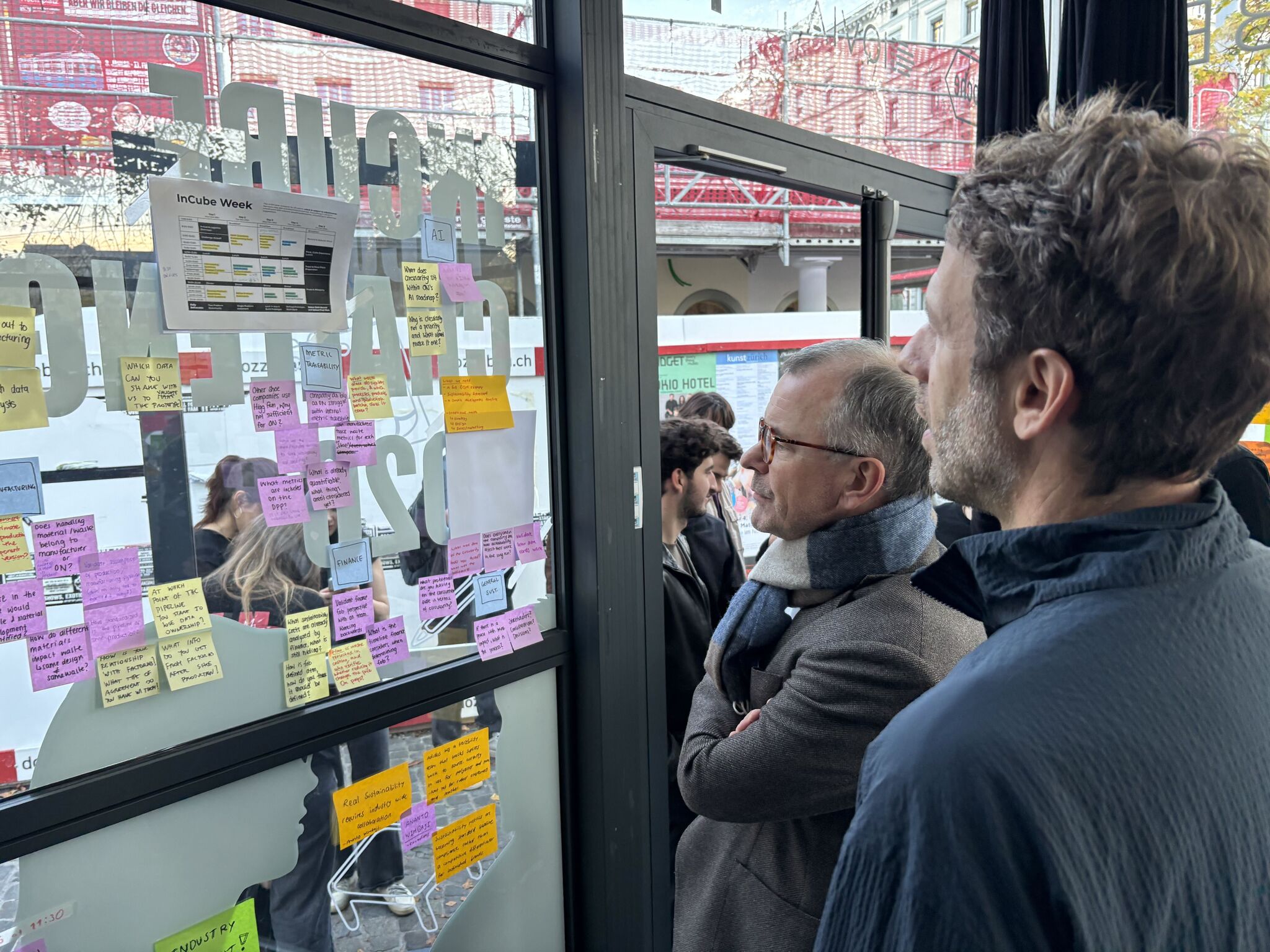 Participants discussing ideas on the On InCube glass wall