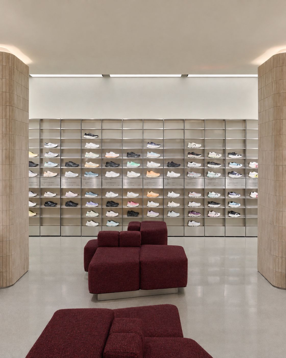 Burgundy seating in front of On Century City’s footwear wall
