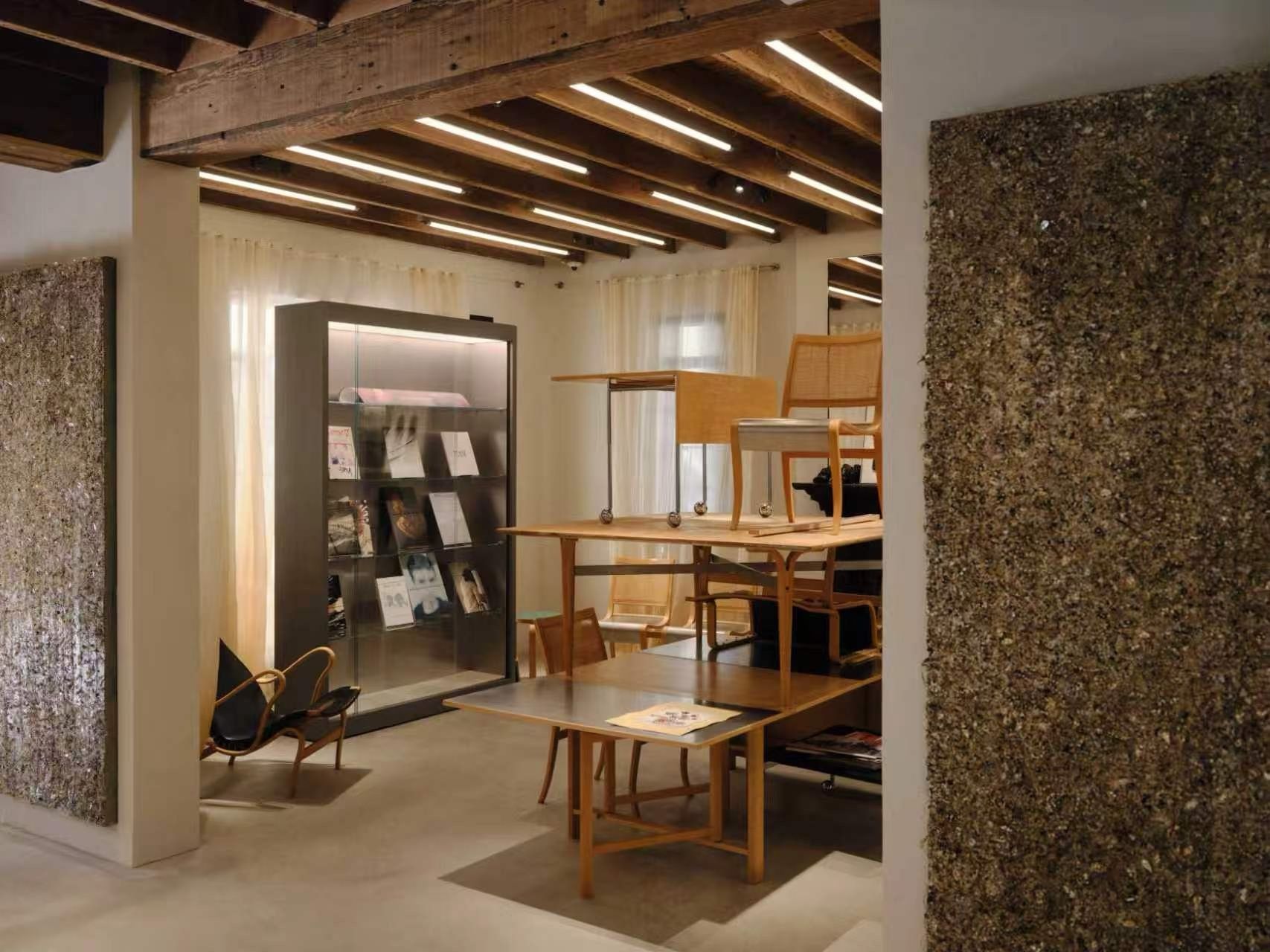 Display tables and exposed timber ceiling inside Our Legacy’s Shanghai store