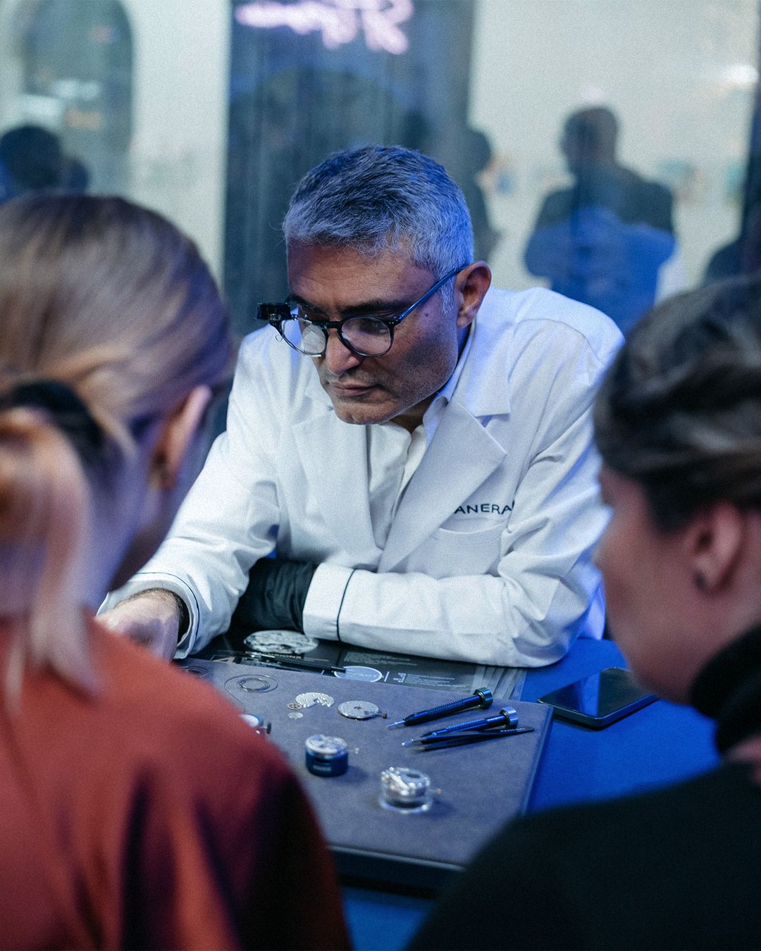 Attendees examine watch components during a hands-on session