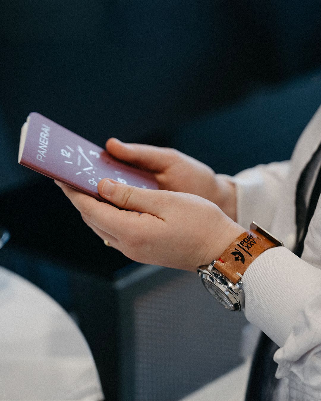 Participant holds an event card while wearing a Panerai watch