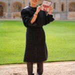 Sandra Choi holding her OBE outside Windsor Castle