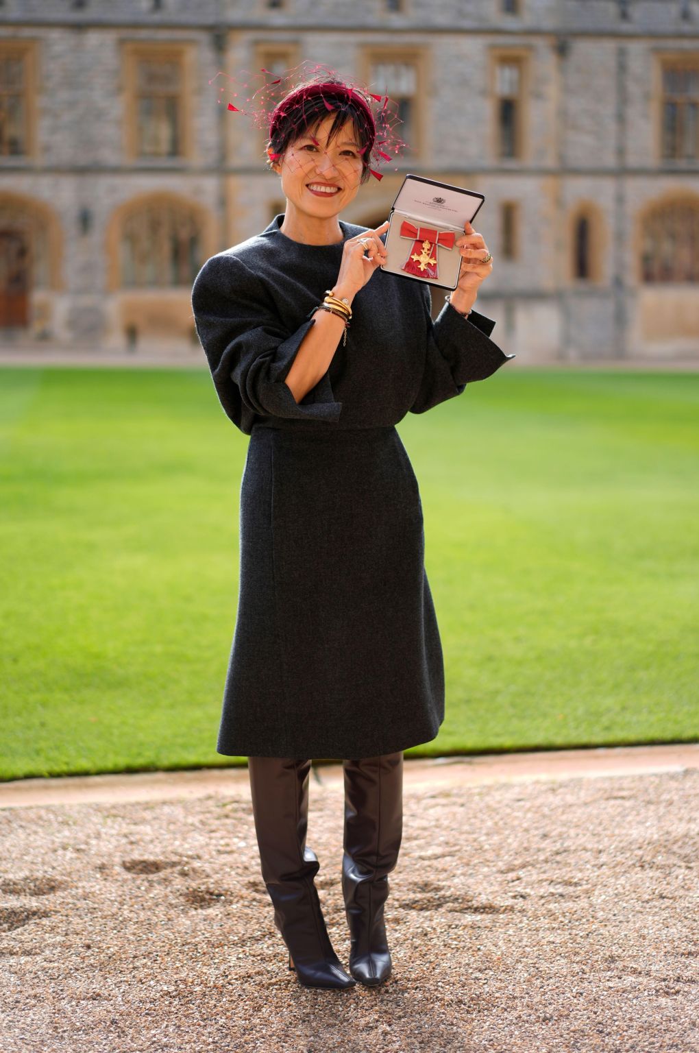 Sandra Choi holding her OBE outside Windsor Castle