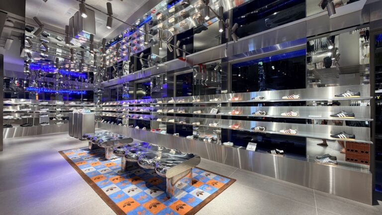 Footwear displayed on reflective shelving inside the adidas flagship.