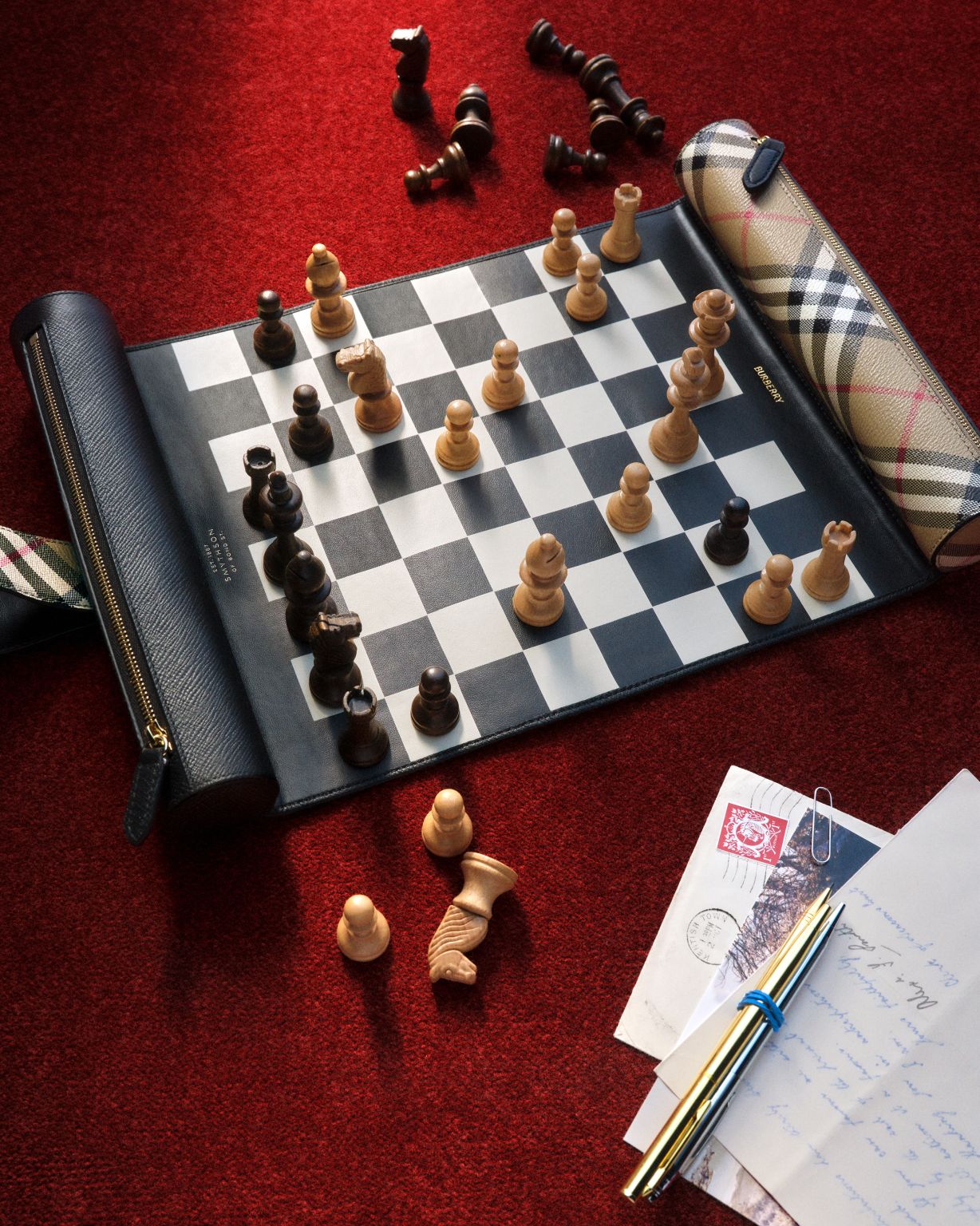 Burberry and Smythson travel chess set with a check roll-up case.