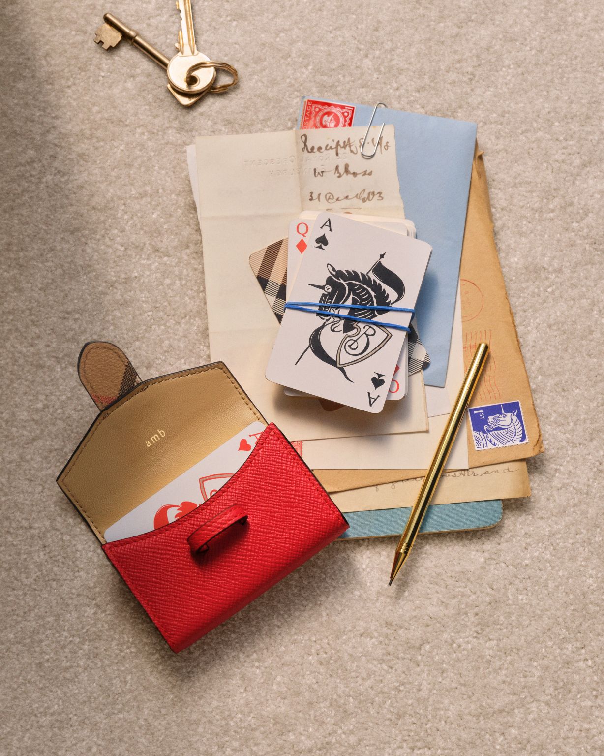 Playing cards and a red leather case from Burberry and Smythson.