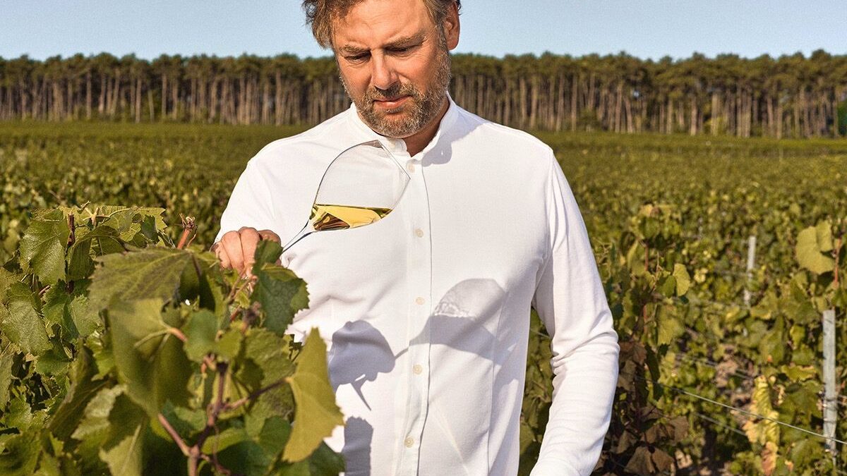 Chef Arnaud Donckele standing among vineyard rows