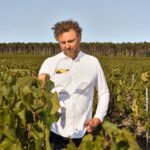 Chef Arnaud Donckele standing among vineyard rows