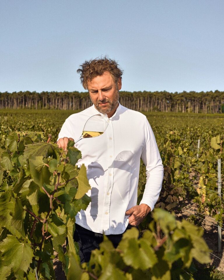 Chef Arnaud Donckele standing among vineyard rows