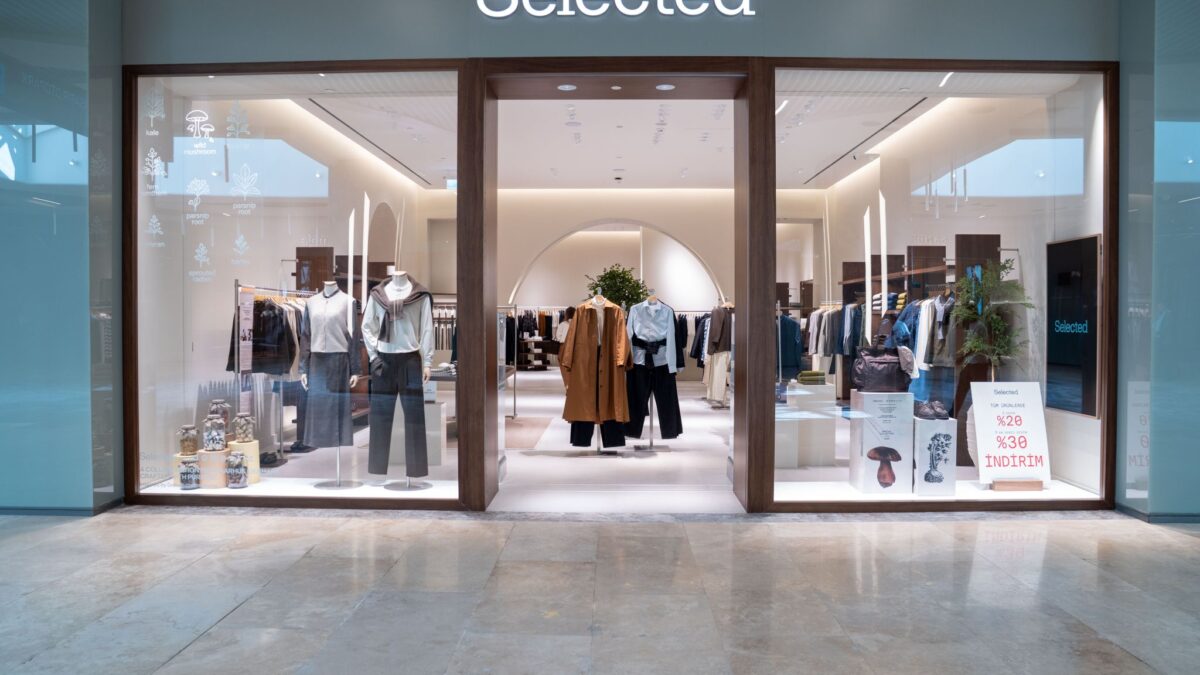 SELECTED storefront with glass doors, clothing displays and a view into the store.