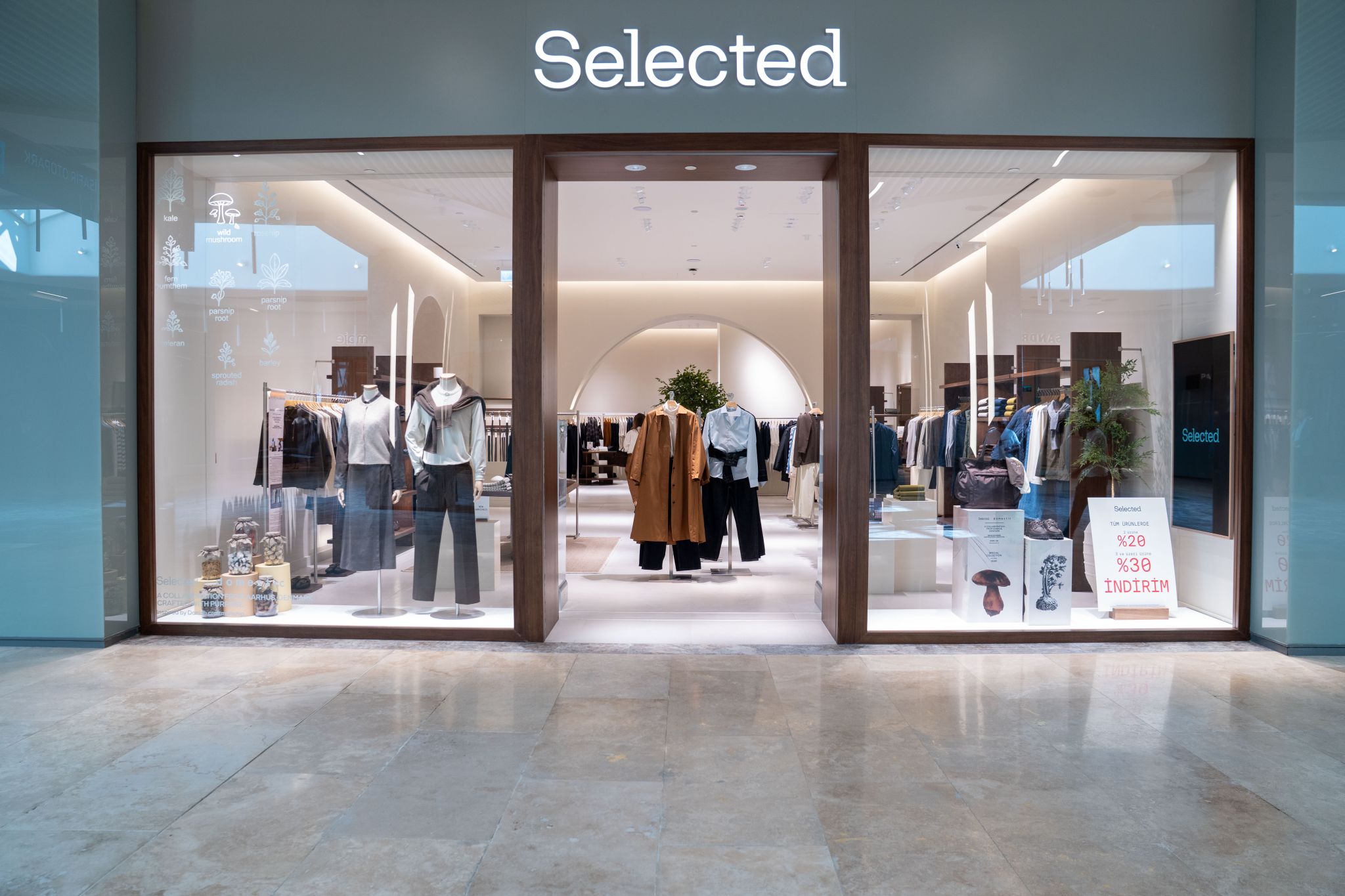 SELECTED storefront with glass doors, clothing displays and a view into the store.