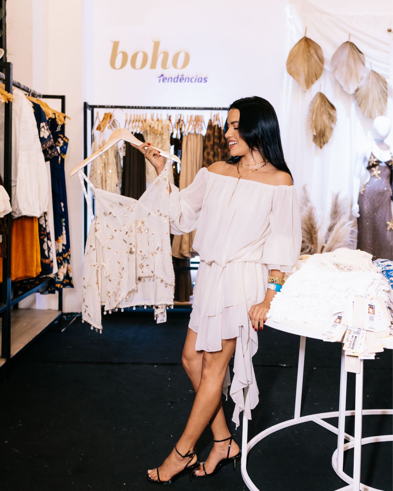 Visitor looking at a white garment in the SHEIN Belém pop-up