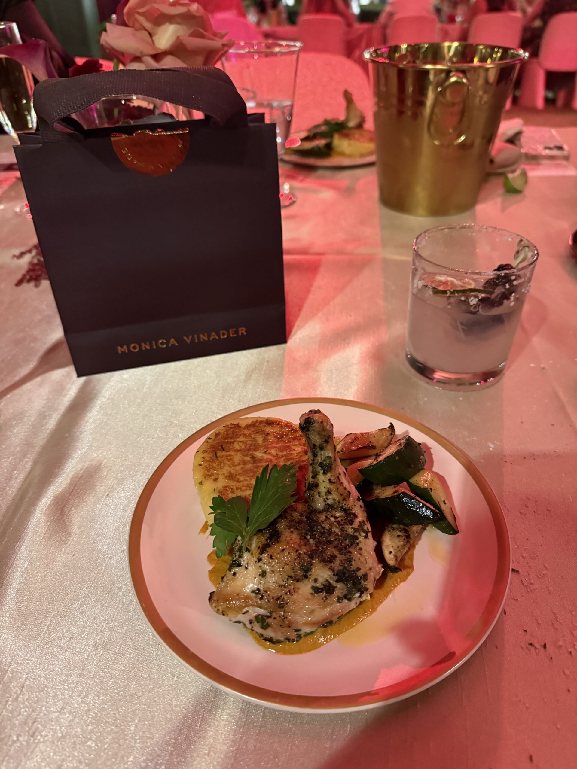 Dinner plate and cocktail beside a Monica Vinader bag at StyleWeekOC