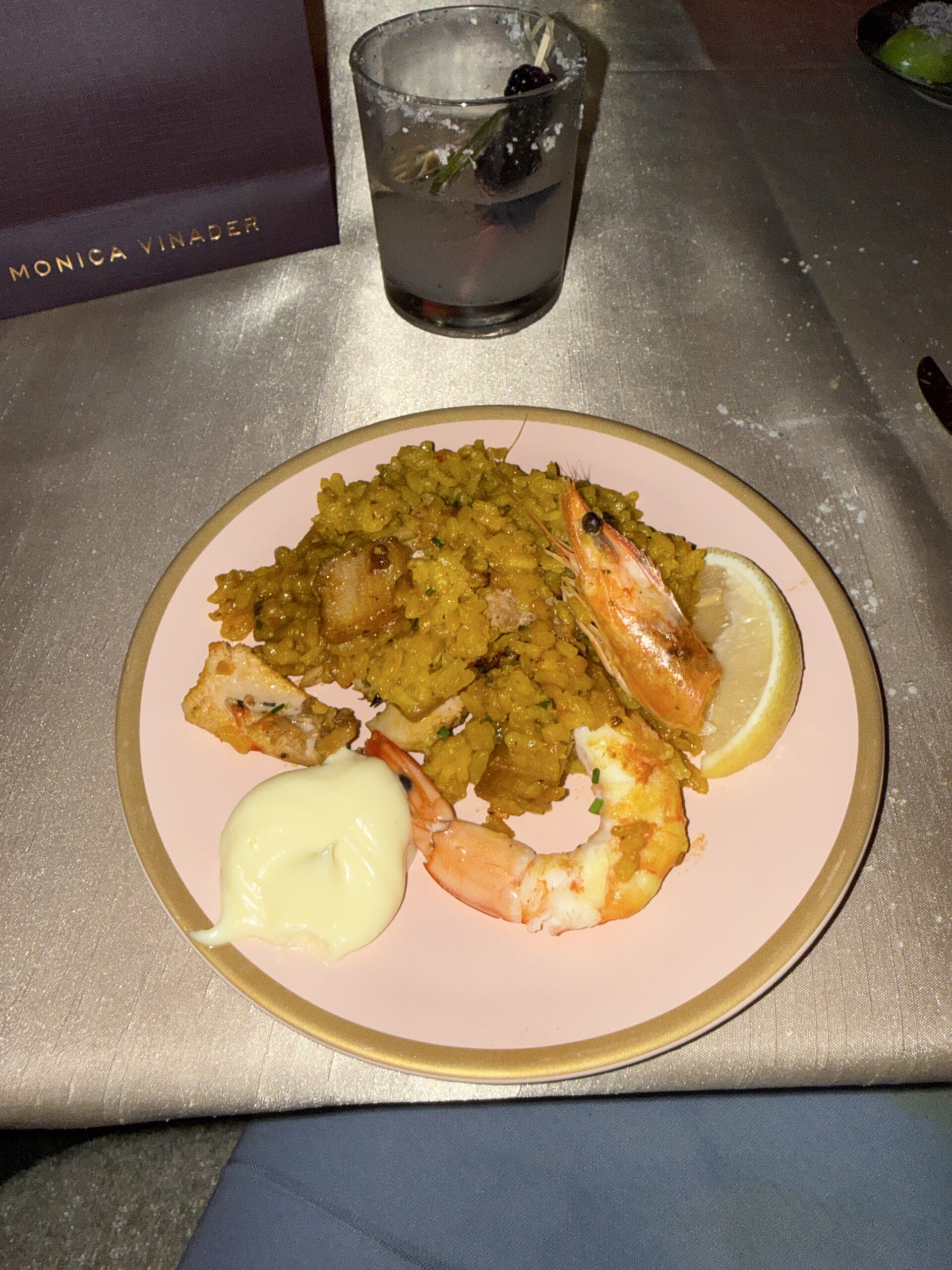 Rice and seafood dinner plate beside a cocktail at StyleWeekOC