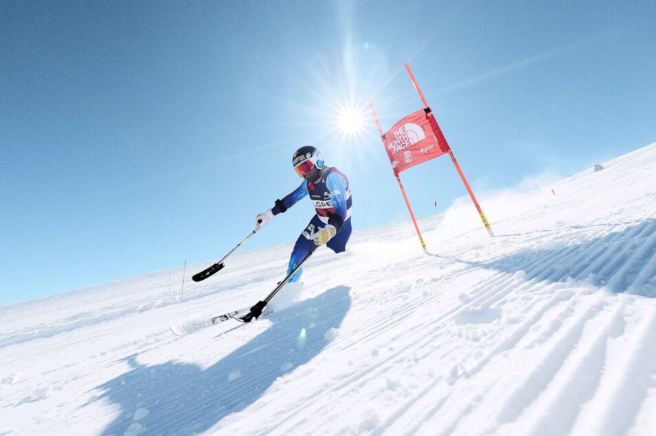 Skier racing past a gate on a snowy slope
