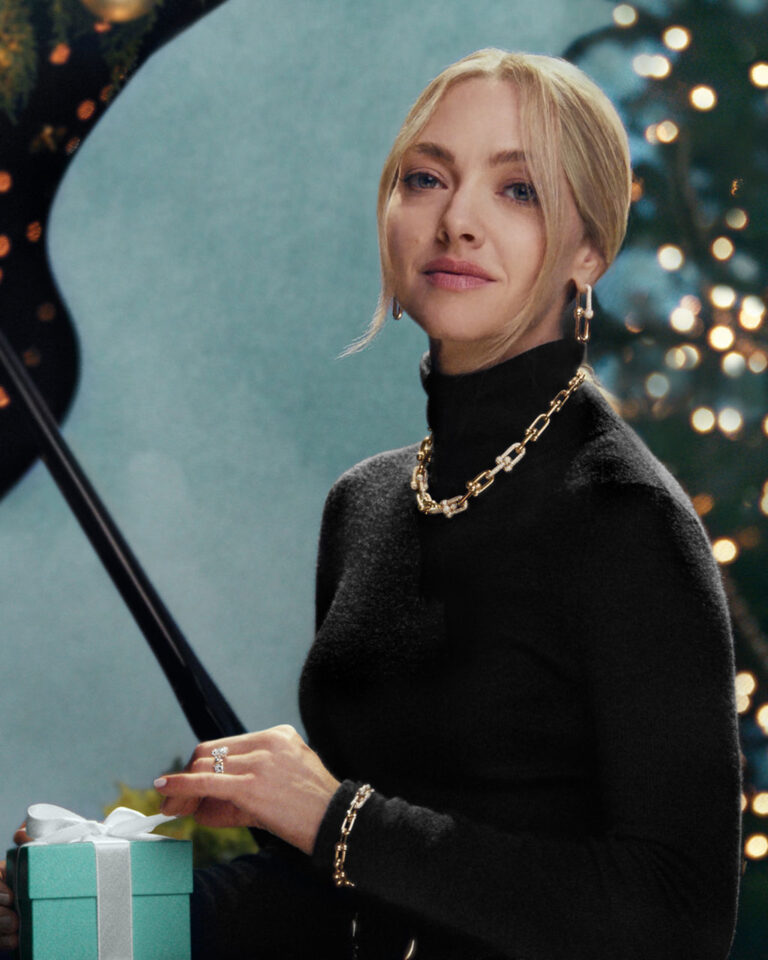 Amanda Seyfried wearing Tiffany HardWear jewelry beside a Christmas tree and a Tiffany Blue Box