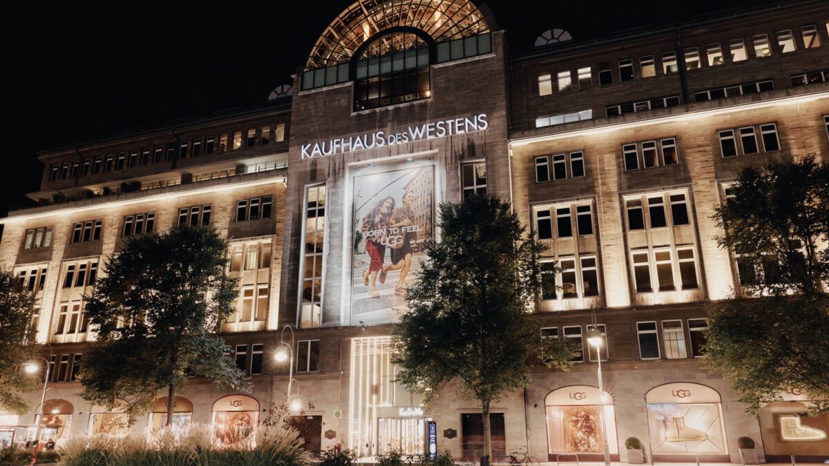 KaDeWe Berlin exterior at night with UGG branding across its facade and windows