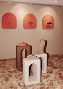 UGG footwear displayed on plinths beneath curved red niches inside KaDeWe