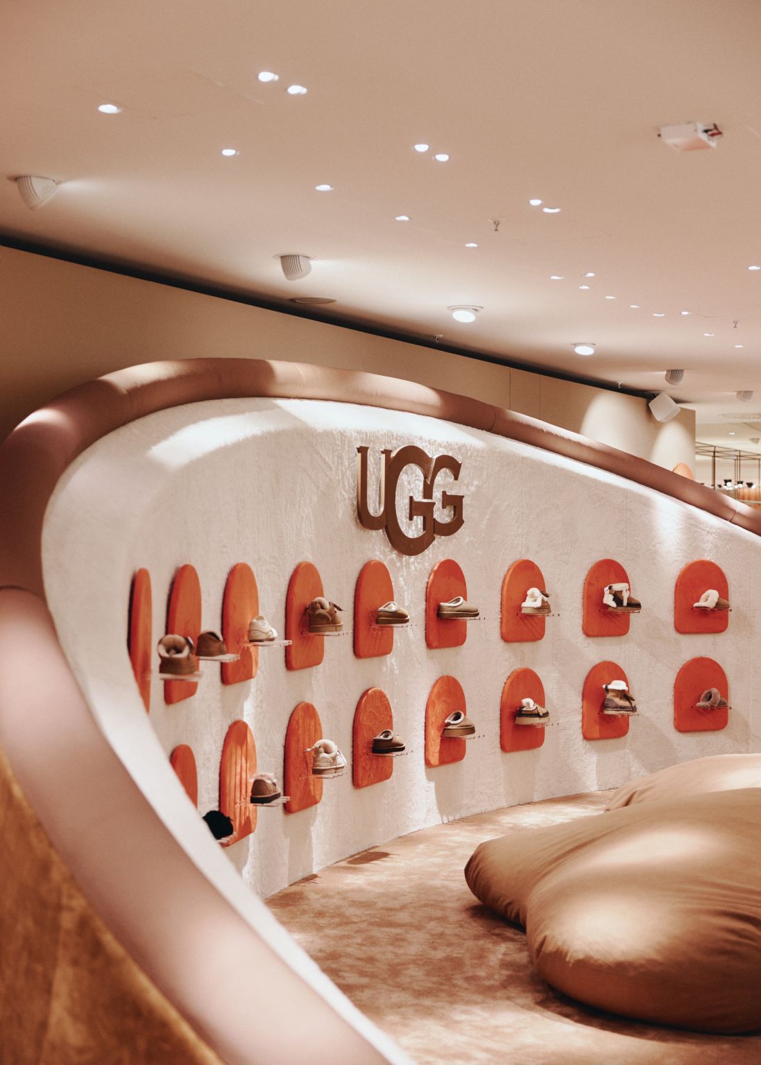 Curved UGG display wall with the brand logo and rows of footwear at KaDeWe