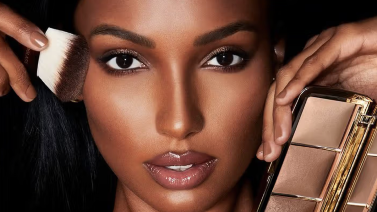 Model holding a makeup brush and face palette.
