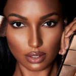 Model holding a makeup brush and face palette.
