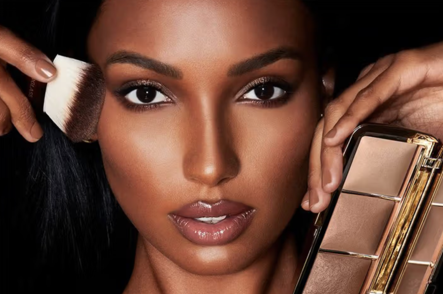 Model holding a makeup brush and face palette.