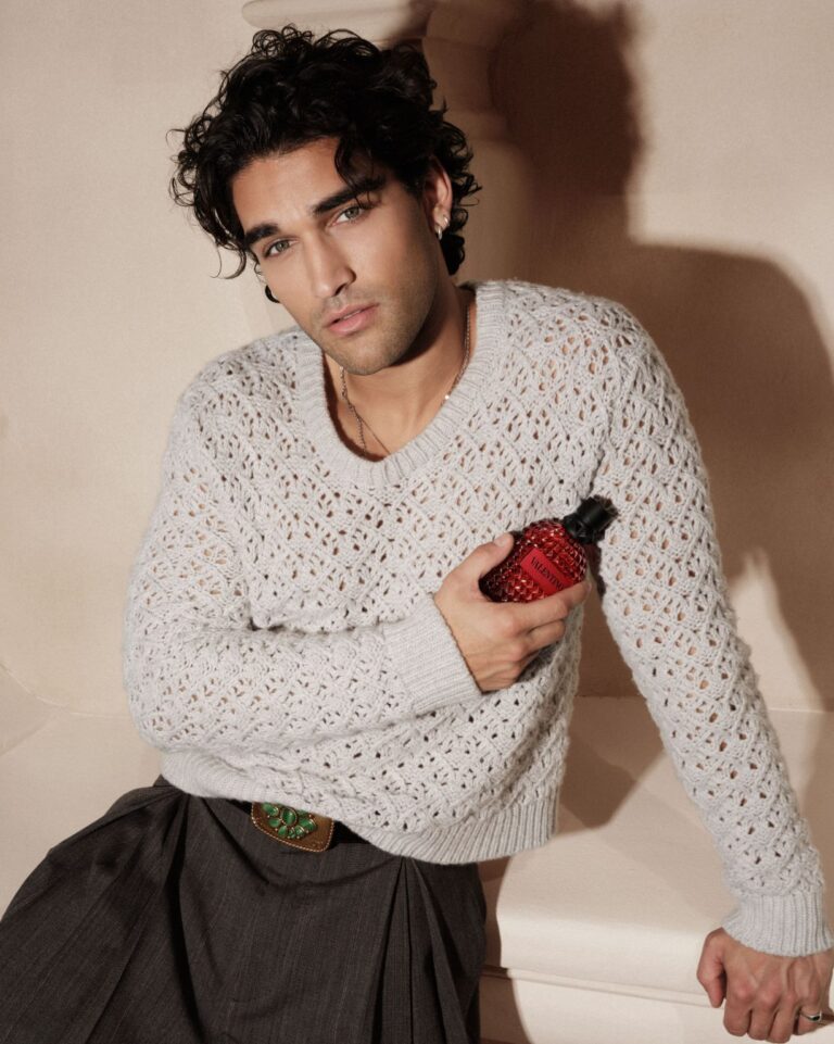 Guest holds a red Valentino fragrance bottle in a show-week portrait