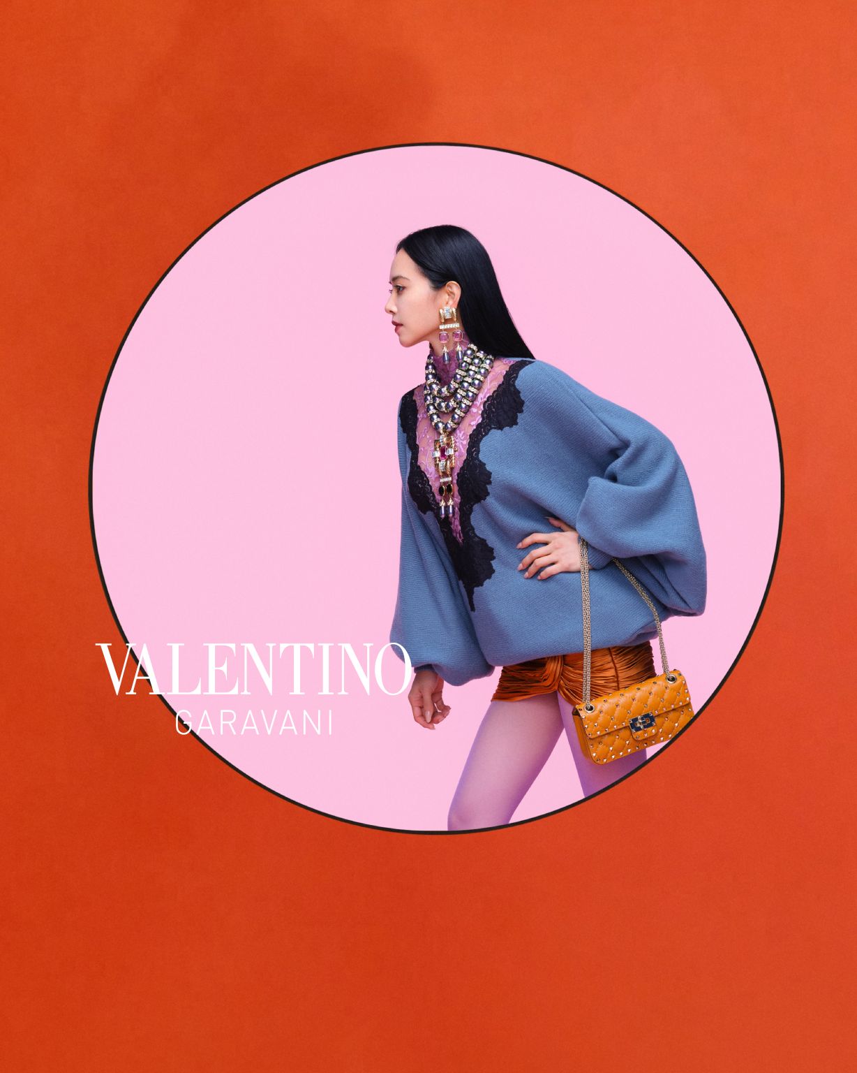 Jolin wearing a blue Valentino jacket against a circular pink backdrop