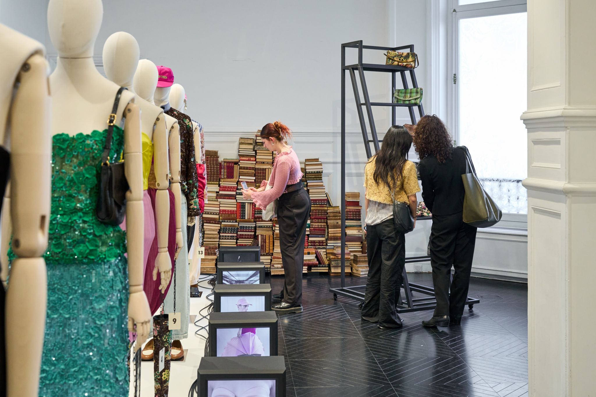 Students examine Valentino Antibiblioteca garments at the Paris resee