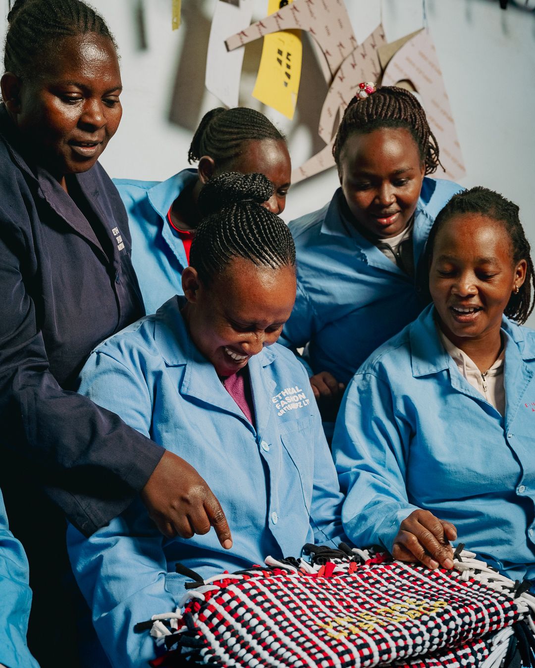 Artisans work together on a patterned bag