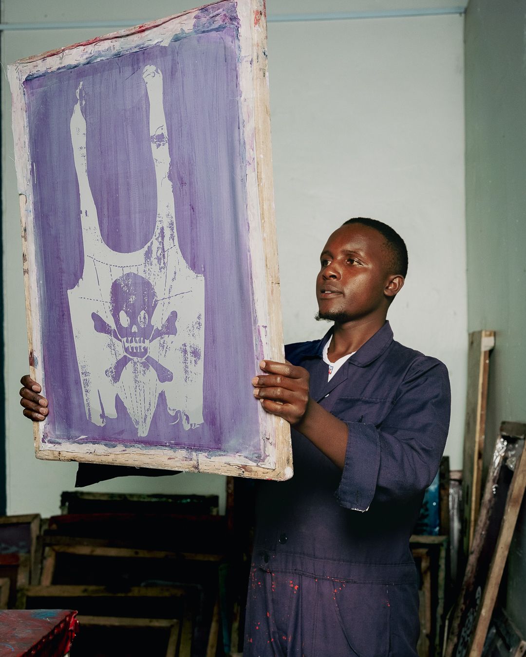 Artisan holds a screen-printing frame bearing the Vivienne Westwood orb